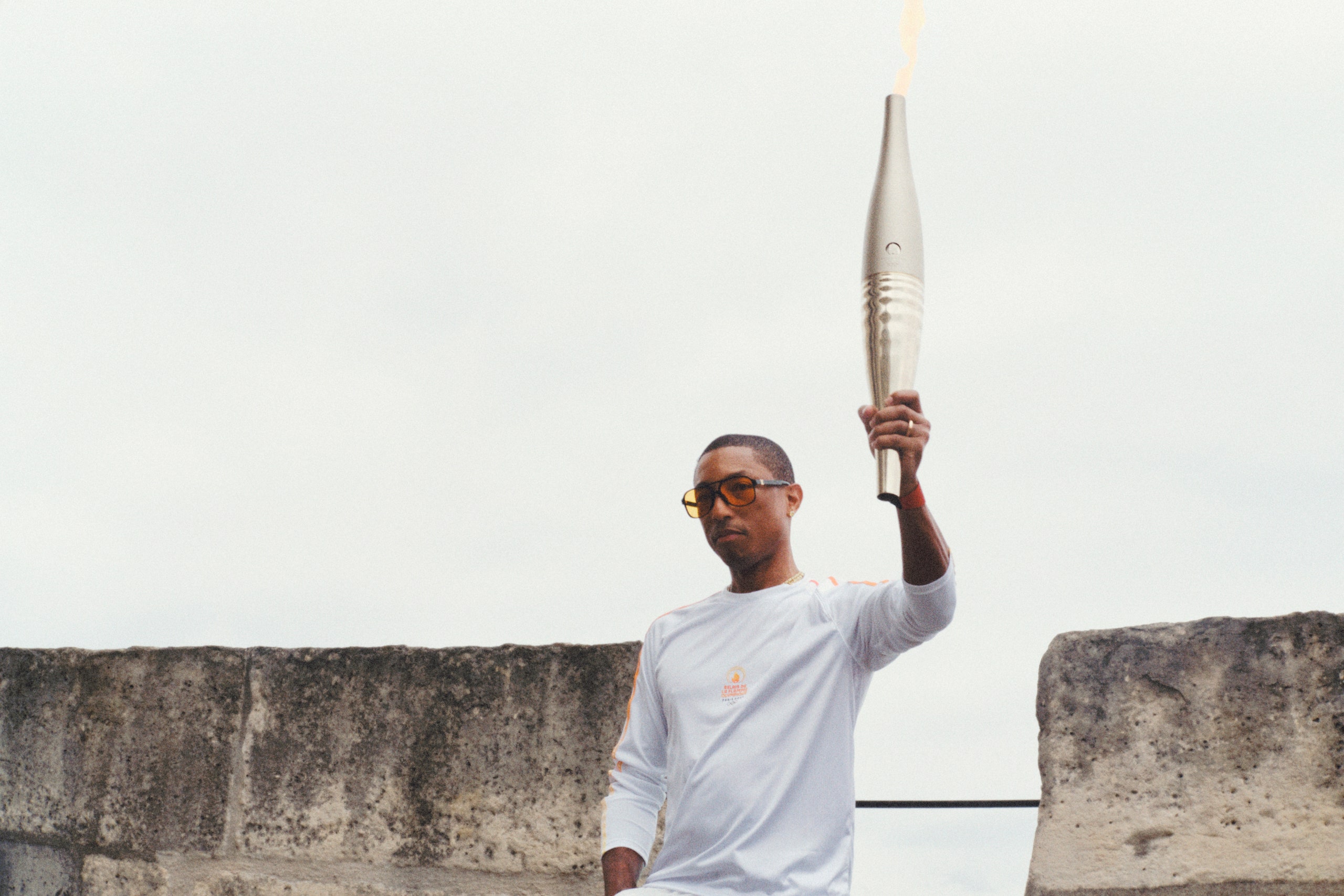 Image may contain Pharrell Williams Light Adult Person Torch Accessories Glasses and People