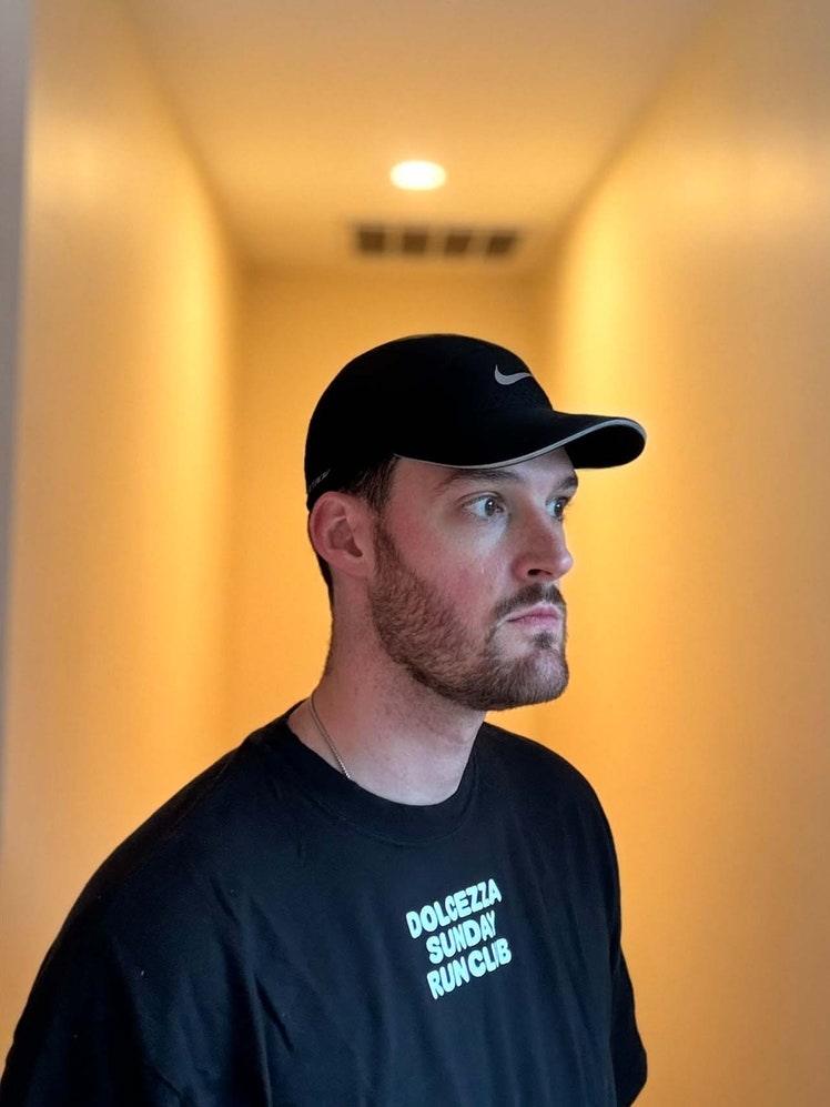 Image may contain: Cap, Clothing, Hat, Head, Person, Baseball Cap, Face, Adult, Crew Cut, Hair, Photography, and Portrait