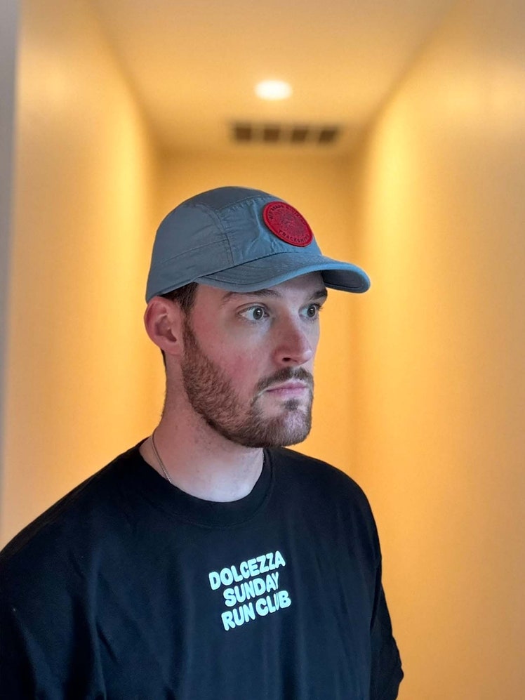 Image may contain: Adult, Person, Cap, Clothing, Hat, Sleeve, Baseball Cap, Head, Face, Crew Cut, and Hair